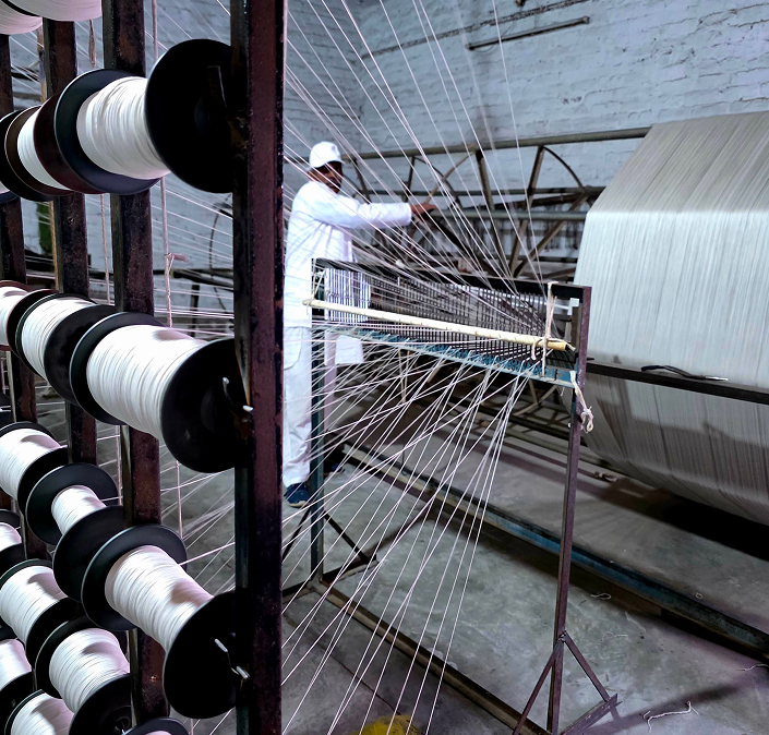 Artisan hand-knotting a luxury carpet on a traditional loom – Kinetic Collection by Habit Collection