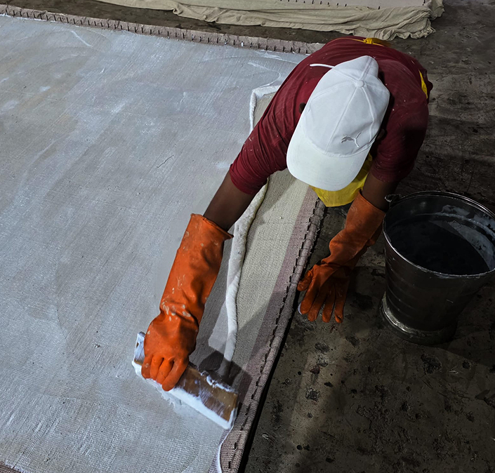 Artisan hand-finishing a luxury carpet in Asian workshop – Natural Collection by Habit Collection